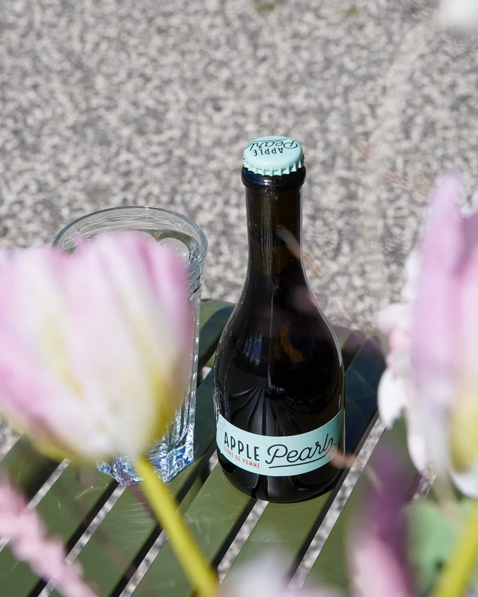 Bouteille de cidre vue à travers les fleurs