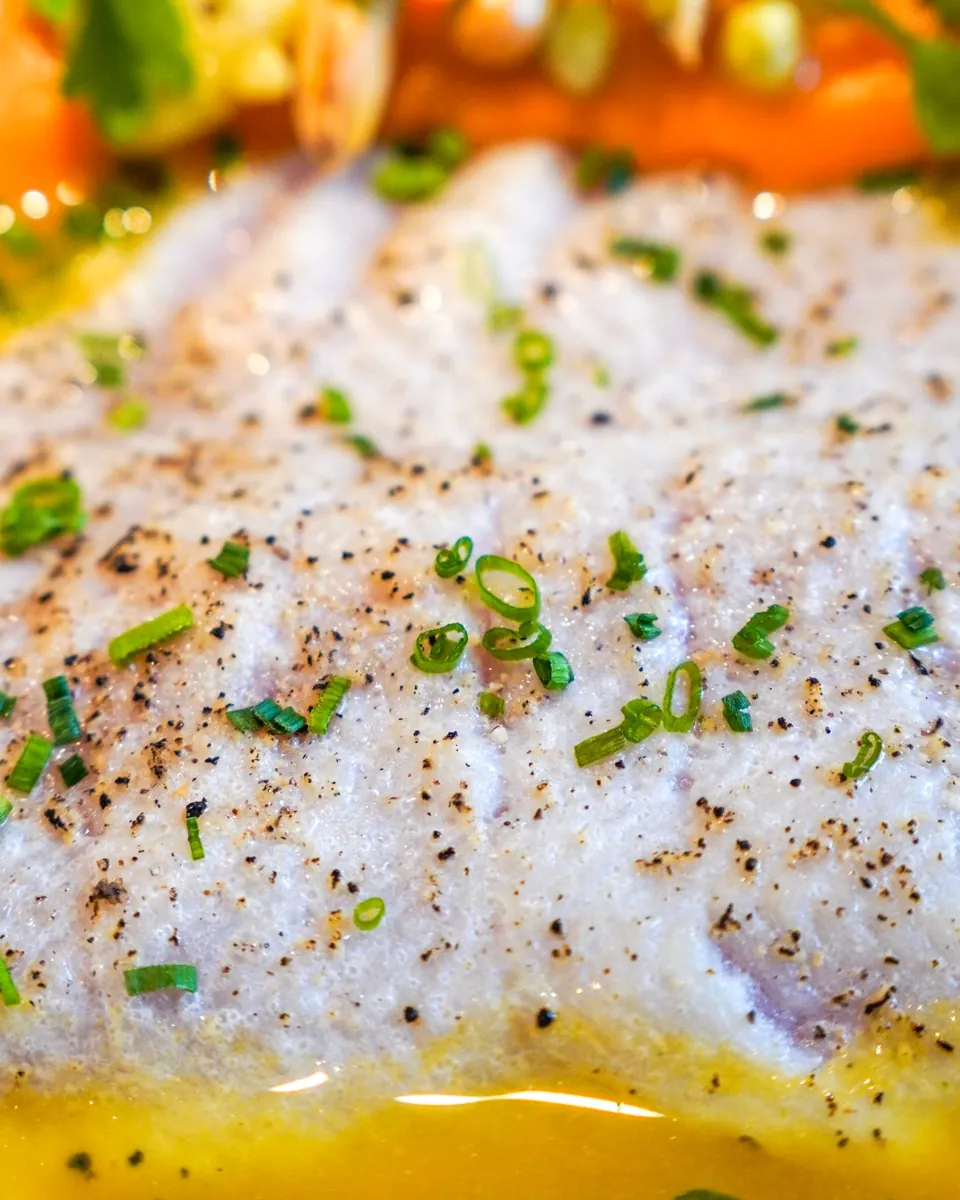 Gros plan sur le poisson, ciboulette et poivre