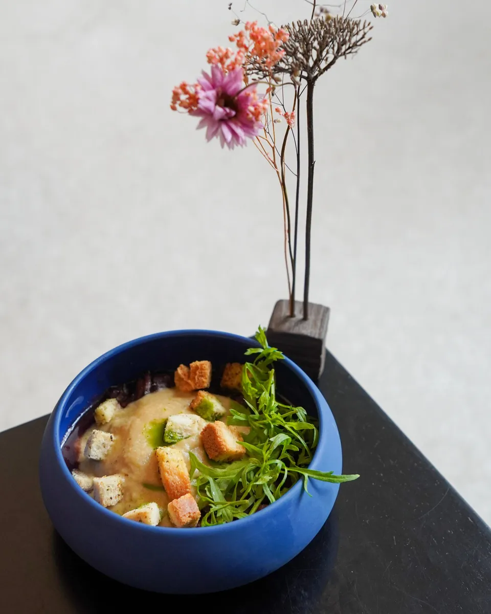 Velouté et croûtons dans un bol bleu, bouquet séché