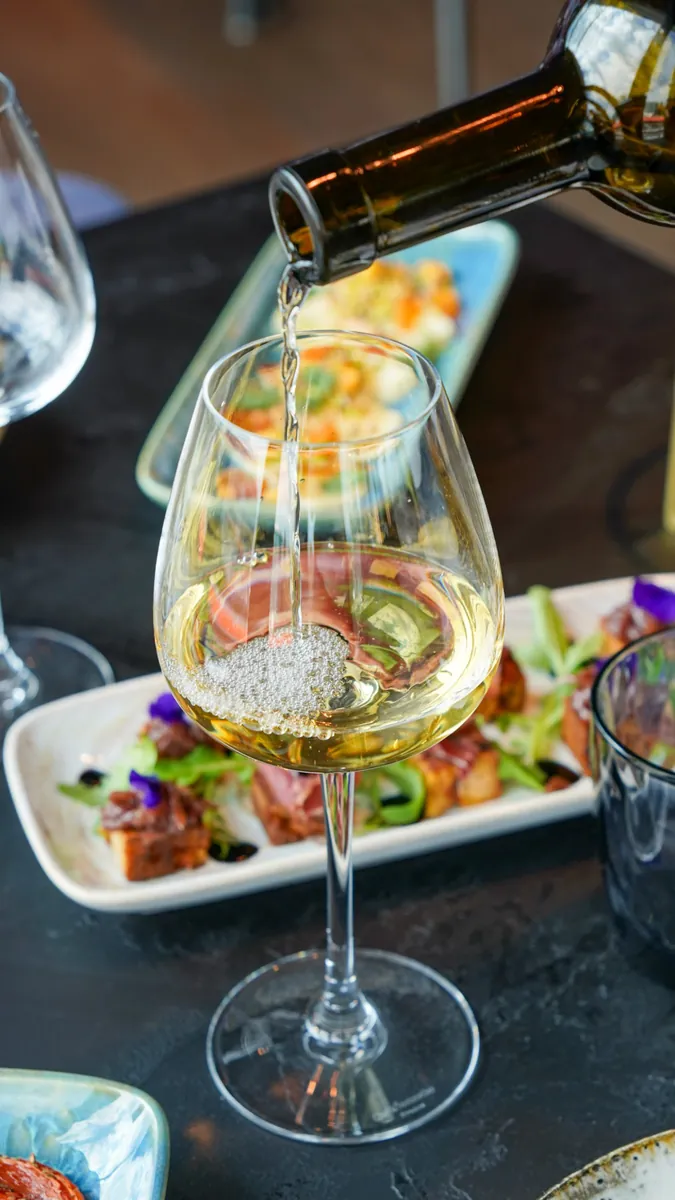 Vin blanc versé dans un verre à pied