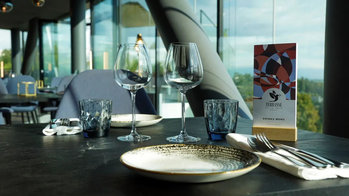 Table dressée face à la vue, carte des boissons